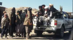 شماری از جنگجویان طالبان سوار بر موتر نوع تویوتا هایلکس، نزدیک پایگاه نظامی بگرام - میزان ۱۳۷۵