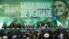 Convenção do PSL tem representantes do partido sentados à mesa sobre palco; no fundo, painel grande com imagembet run apostas esportivasBolsonaro e dizeres: 'Muda Brasilbet run apostas esportivasverdade'