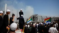 پلیس مرزی اسرائیل در حالی که دروزی‌های اسرائیلی برای بررسی وضع اعضای خانواده خود در سوریه از مرز عبور می‌کنند، نظاره‌گر است