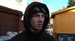 Jovem usando roupas de frio e dando entrevista 