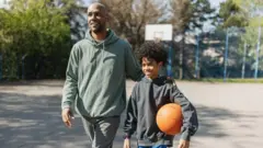 Homem e menino em quadra de basquete