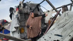 Mulher palestinawww bet3uma das tendas destruídas pelo ataque israelense no domingo