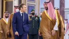 الرئيس الفرنسي إيمانويل ماكرون مع ولي العهد السعودي محمد بن سلمان في جدة في ديسمبر/كانون أول 2021