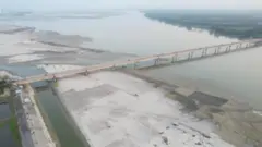ওপর থেকে তোলা ছবিতে তিস্তা নদীর ওপর সেতু দেখা যাচ্ছে, একপাশে নদীর তীরে চর পড়েছে