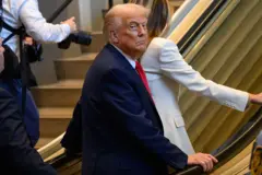 Trump e a esposa na ponta de uma escada rolante