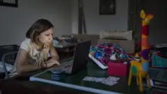Perempuan memandang laptop.