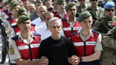 Akın Öztürk, diğer sanıklarla birlikte duruşma salonuna getirilirken