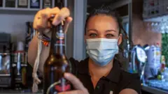 Una camarera sirve una cerveza