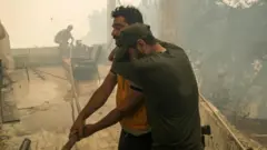 أفراد إطفاء سوريون يشاركون في إخماد الحرائق في ريف اللاذقية