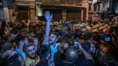 Protesters clash with Turkish anti-riot police officers as they gather to protest the LeMan magazine cartoon in Istanbul on 30 June 2025. 