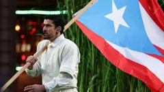 Bad Bunny carregando bandeira de Porto Rico no show do intervalo do Super Bowl, em 8 de fevereiro de 2026, em Santa Clara, Califórnia.
