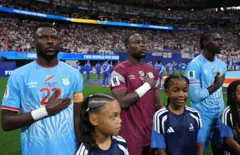 Chancel Mbemba (n° 22), Lionel Mpasi (n° 1) et Axel Tuanzebe (n° 4), joueurs de la RD Congo, sont alignés pour l'hymne national avant le match des seizièmes de finale de la Coupe du Monde de la FIFA 2026 opposant l'Angleterre à la RD Congo