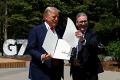 O presidente dos EUA, Donald Trump, e o primeiro-ministro britânico, Keir Starmer, celebrando um acordo comercial assinado durante uma reunião na cúpula do G7