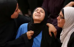 سيدة فلسطينية خلال جنازة أحد ذويها الذين قُتلوا يوم الأحد بنيران إسرائيلية أثناء الحصول على المساعدات في شمال غزة، في مستشفى الشفاء في مدينة غزة، 23 يونيو / حزيران 2025