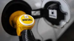 Carro sendo abastecido com diesel em um posto.