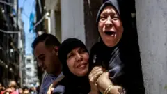 Grandmother of 15-year-old Mahmud Tolba, who was killed in Israeli air strike, mourns during his funeral in Al Zaitun neighborhood in the east of Gaza City