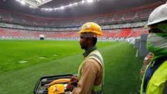 عامل في ملعب كرة قدم بقطر يتم تجهيزة لمونديال 202