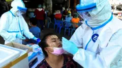 A medical worker performs a nose swab on a migrant worker at a seafood market, amid the coronavirus disease (COVID-19) outbreak, in Samut Sakhon province, in Thailand, December 19, 2020