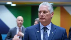 Miguel Díaz-Canel, presidente de Cuba, vestido con un traje azul y corbata del mismo color. Se ven personas detrás difuminadas