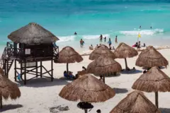 Una vista de una playa de Jamaica con los toldos hechos de palma para refugiarse del sol en la orilla.