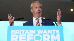 「イギリスはリフォームを欲している」と記された演台に立ったファラージ氏が、両手を広げて斜め前方を見ながら口を開けている