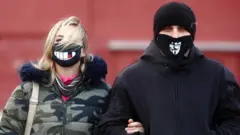 A couple wearing decorated face masks