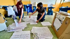 Miembros electorales cuentan los votos tras el cierre de un centro de votación en Guayaquil, Ecuador, el 9 de febrero de 2025. 