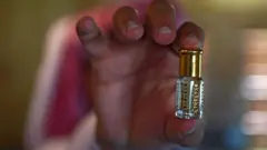 سلمان، أحد أفراد عائلة بن سلمان، يزن الورود أثناء عملية التقطير في مزرعة العائلة بمدينة الطائف السعودية، في 13 مارس/آذار 2021. مزرعة العائلة مفتوحة للزوار، وتقدم تجربة ريفية متكاملة، تشمل مشاهدة التقليد العريق لاستخراج ماء وزيت الورد من ورد الطائف، وهو مكون ثمين في صناعات التجميل والطهي وغيرها. وقد أصبح هذا الورد مرادفاً للمدينة نفسها، التي تُعرف محلياً باسم "مدينة الورد".
