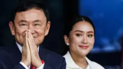 تاكسين شيناواترا يحيي أنصاره مع ابنته الصغرى بيتونغتارن شيناواترا في 22 أغسطس/آب 2023.