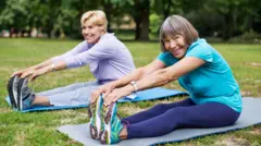 Duas mulheres alongando as pernas sentadassimular aposta esporte netum gramado.