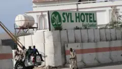 Abasirikare ba leta ya Somalia baboneka ku muryango wa hoteli Syl i Mogadishu, kuri iyi foto yo mu 2019