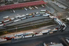 Vista aérea de una lista de camiones de carga que esperan por ser revisados en San Diego.