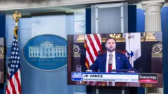 2025年9月15日，美國副總統JD萬斯出現在白宮新聞發布室的電視監視器上，萬斯正在主持《查理‧柯克秀》（The Charlie Kirk Show）的節目，悼念在美國華盛頓特區遇害的保守派活動家查理·柯克