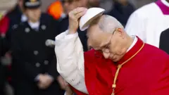 Leão 14 tirando solidéu, olhando para baixo