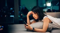 شابة صينية تستعمل هاتفها الذكي