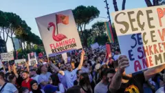Un hombre sostiene un cartel con un flamengo y la frase "Revolución del flamenco".
