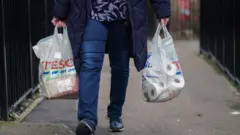 Tesco torbası taşıyan bir kadın