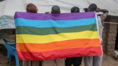 Abantu bagaragara mu bitugu bafite ibendera rizwi nk'iriranga abatinganyi