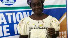 Sylvia Jabbie présentant un certificat de récompense