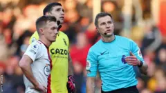 የማሃል ዳኛው ሚካሄል ሳልስበሪ ከቡድኖቹ አምበሎች ጄምስ ዋርድ-ፕሮውስ እና ኤሚሊያኖ ማርቲኔዝ ጋር ስለ ድሮኗ ሲነጋገሩ 