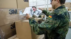 جندي ألماني يفتح صندوق كمامات