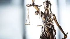Figura de la justicia con los ojos vendados y sujetando una balanza y una espada