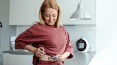 una mujer se inyecta un péptido 