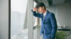 Sad young business man resting by the window
