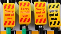 An "out of use" sign covers fuel pumps at a petrol station in Birkenhead, northwest England on September 27, 2021