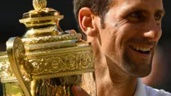 Novak Đoković drži pehar sa Vimbldona