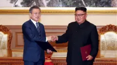 문재인 대통령과 김정은 북한 국무위원장이 2018년 9월19일 평양 백화원 영빈관에서 정상회담을 마치고 평양공동선언서에 서명한 뒤 교환하고 있다.