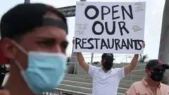 Alex Aguilar (C) along with restaurant owners, workers and supporters gather to protest new measures