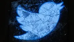 El logo de Twitter bajo un cristal roto