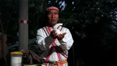 Shainkiam Yampik Wananch, diácono ordenado por la Iglesia Católica, sostiene hostias durante una liturgia con indígenas Achuar en una capilla en Wijint, una aldea en la Amazonía peruana, en Perú, el 20 de agosto de 2019.